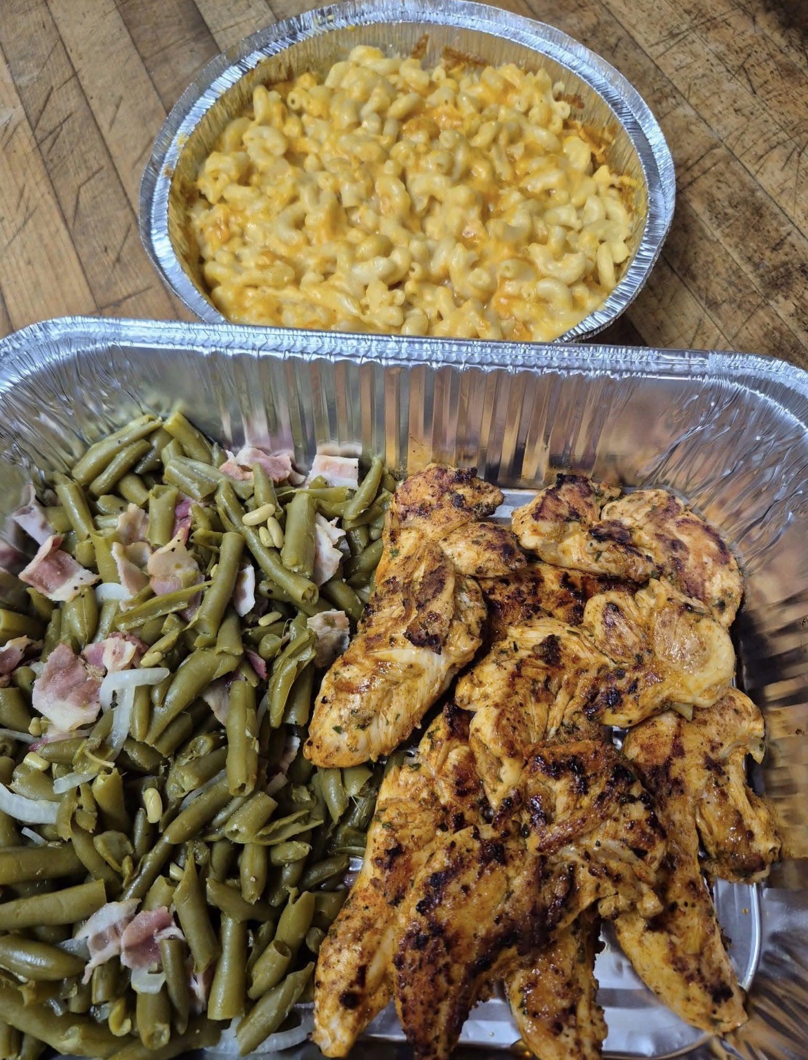 Catering pans of grilled chicken, green beans and mac and cheese